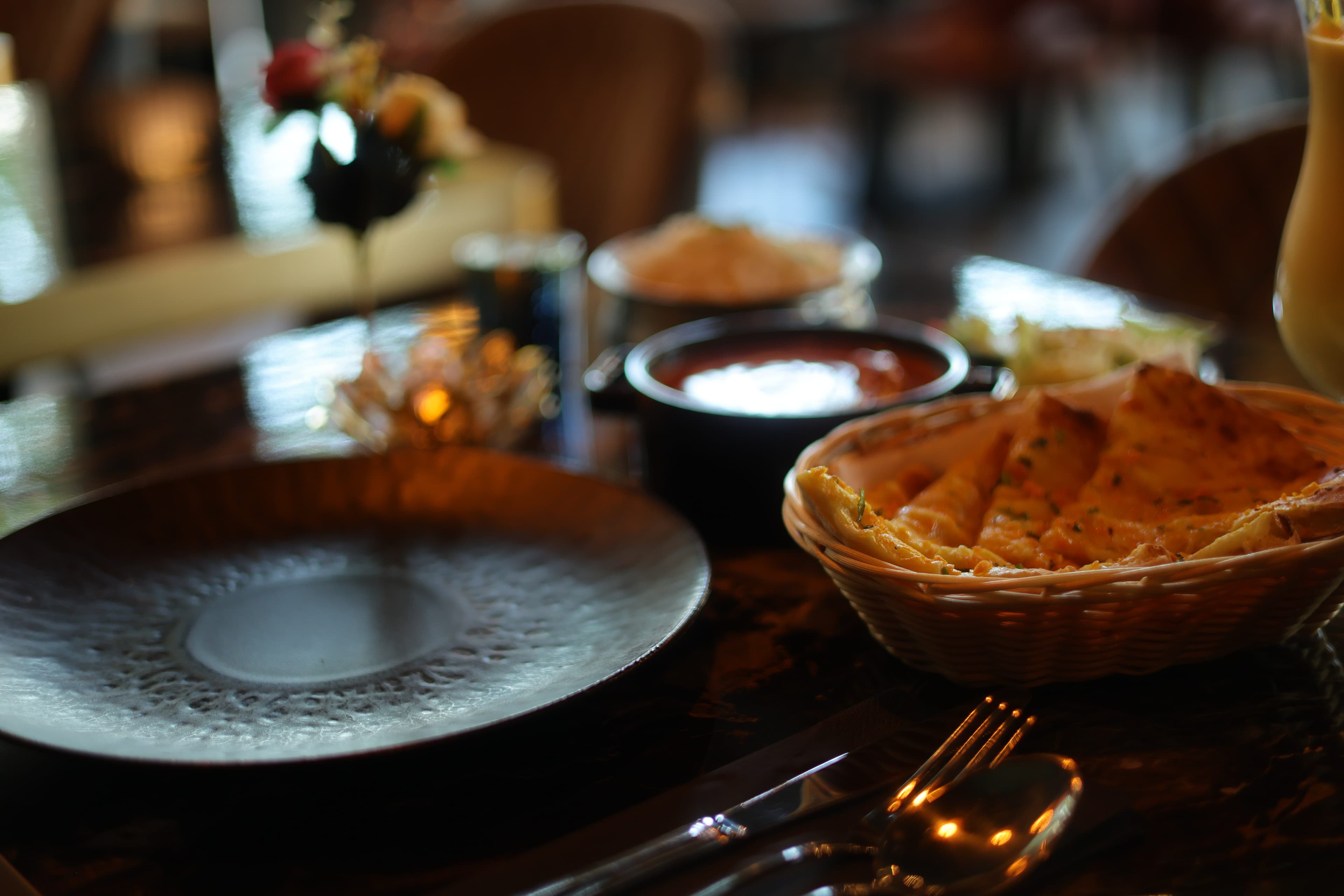 Gedekte tafel met naan, gouden bestek en dipsauzen